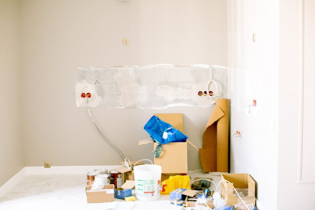 pexels-photo-3615721 A room undergoing renovation with tools, supplies, wiring, and paint cans scattered around.